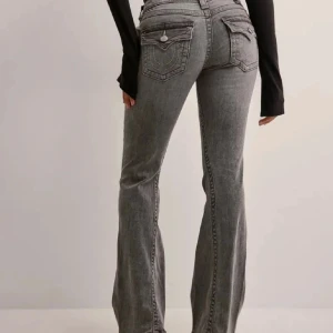 Gråa True religion jeans  - Säljer gråa True religion jeans i storlek w25 i modellen joey. Köpta från Nelly för 1299kr. I bra skick dock har ena knappen åkt av men annars inga defekter förutom kanske lite slitna längst ner men inget man lägger märke till. Skriv privat för egna bilder. Skicka gärna prisförslag 💕💕