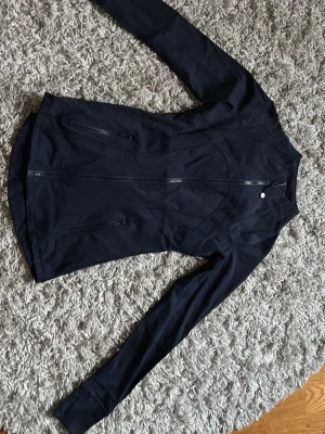 Svart lululemon träningsjacka - Snygg svart träningsjacka från Lululemon. Använd ett par gånger i väldigt fint skick ändå. Säljer åt min flickvän.