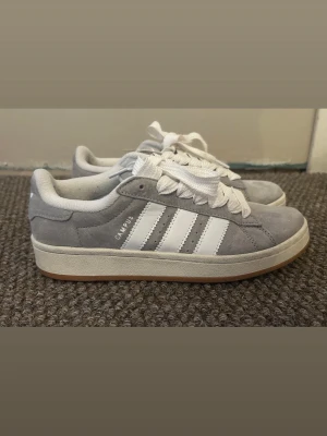 Campus adidasskor  - Grå campus adidasskor i storlek 39, använda men i bra skick och hela, extra skosnören ingår. 