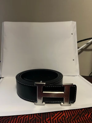 Svart H bälte - Stilrent svart bälte som passar alla stilar. Perfekt om man vill ha det lilla extra som får outfiten att lysa