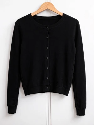 Svart basic kofta med knappar - En stilren svart kofta med rund halsringning och knäppning framtill. Långärmad modell med ribbade muddar och nederkant. Perfekt att matcha med jeans eller kjol för en clean look.