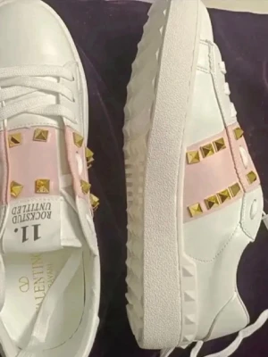 Vita sneakers med rosa och nitar söker - SÖKER I 38 ELLER 39. Helst de med guldiga nitar men rosa funkar. Kan betala bra