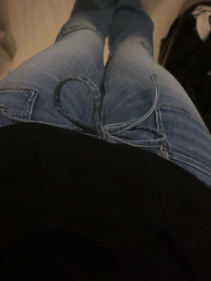 Blå bootcut jeans - Säljer ett par ljusblå bootcut jeans med snygg snörning i midjan💕från Gina teen14+ i storlek S nya andvända 1 gång