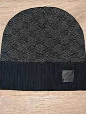 Mörkgrå ribbad mössa med patch - Snygg mörkgrå mössa med diskret rutmönster och bred ribbad kant. På kanten sitter en svart patch med logga som ger en stilren touch. Perfekt accessoar för kalla dagar och enkel att matcha med olika outfits.