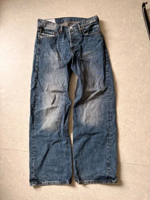 Blå loose fit jeans från H&M - Ett par blå jeans från H&M med straight loose fit. Jeansen har klassisk femficksdesign, raka ben och är tillverkade i denim. Perfekta för en avslappnad och trendig stil.