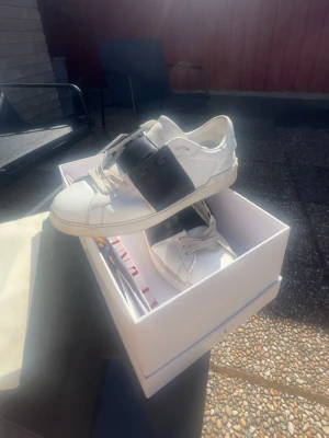 Valentino vita sneakers med svart band - Säljer ett stilrena Valentino Opens 9/10 skick har tagit väl hand om dem passar även bra som sommarskor om du vill ha nåt mer upp fräschande och unikt till sommaren. Kom gärna DM om du har frågor eller vill du diskutera pris😄😁