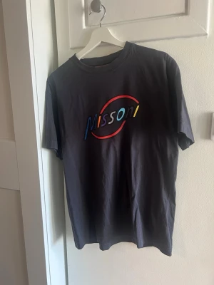 Mörkblå Missoni t-shirt med tryck - Cool mörkblå t-shirt från Missoni med färgglatt tryck på bröstet. Klassisk passform med rund hals och korta ärmar. Perfekt för dig som gillar stilrena plagg med en twist.