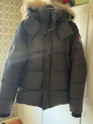 Svart dunjacka från Canada Goose - Canada goose wyndham i storlek S, original paket/kartong samt förvaringspåse och hänge medföljer. Kvitto finns köpt för ca 17000kr. Äkta päls, rökfri och inga husdjur  skick 8/10 inga skador på jackan. Färgen är grå 