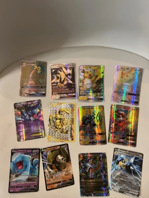 Pokémon holografiska samlarkort - Säljer ett set med 12 stycken Pokémon holografiska samlarkort, bland annat Raichu GX, Blaziken GX, Wobbuffet V och Melmetal GX. Korten har färgglada och glansiga ytor med olika motiv och attacker. Perfekt för dig som vill utöka din Pokémon-kortsamling.