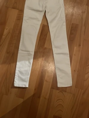  jeans från Replay - Säljer ett par vita jeans från Replay med klassisk femficksdesign och silverfärgade nitar. Jeansen har normal midja och är tillverkade i ett stretchigt bomullsmaterial för skön passform. Perfekta till sneakers.