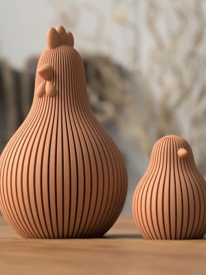 Dekorativa hönor i terrakotta - Två dekorativa hönor i terrakottafärg med räfflad yta och stilren, rundad form. Den större har detaljer som kam och näbb, medan den mindre är enklare. Perfekta som prydnad i hemmet för dig som gillar unik inredning.