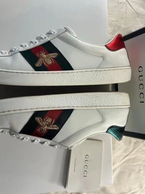 Äkta Gucci Ace I 42 I Mycket bra skick! - Äkta Gucci Ace Bee i storlek 42. Skicket är mycket bra utan några några tydliga defekter, dock en liten reda på ena tån. Låda och äkthetsbevis följer med. Hör av dig vid frågor eller prisförslag!
