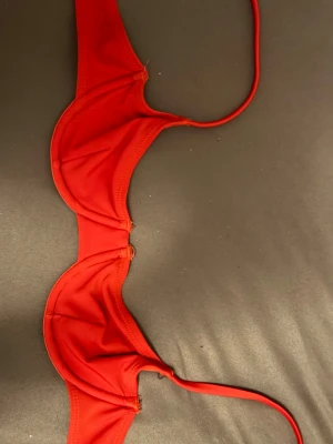Röd bikiniöverdel med bygel från NA-KD - Snygg röd bikiniöverdel med bygel och tunna axelband. Klassisk modell med enkel design och utan mönster. Perfekt för strandhäng eller poolparty. Materialet känns mjukt och följsamt mot huden. Lite sliten vid bygeln