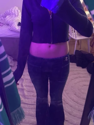 Mörkblå cropped ziptröja - Säljer en mörkblå cropped ziptröja med långa ärmar och ribbad nederkant. Tröjan har dragkedja framtill och är i ett mjukt stickat material. Perfekt för en trendig och avslappnad look. Knappt använd