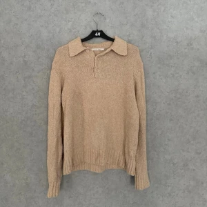 Beige stickad tröja A Days March - Stickad tröja i beige från A Day's March med klassisk krage och knäppning framtill. Tröjan har lång ärm, ribbade muddar och är tillverkad i ett mjukt, grovt stickat material. Perfekt för lager på lager och en avslappnad stil.