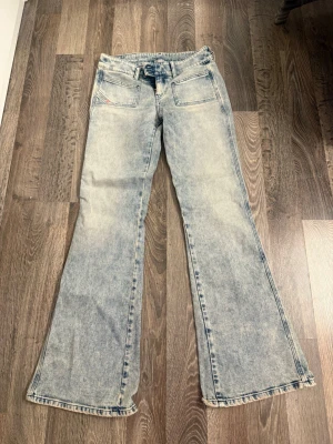 Ljusblå bootcut jeans från Diesel - Säljer ett par ljusblå bootcut jeans från Diesel med snygg tvättad look och raka, utsvängda ben. 