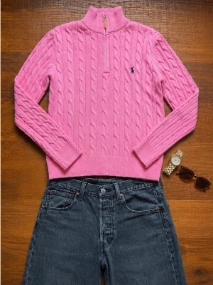Ralph Lauren Kabelstickad Half-Zip Herr Large Rosa  - Snygg Polo Ralph Lauren kabelstickad tröja i rosa färg med half zip och broderad logga på bröstet. En av Ralph Laurens mest populära modeller som passar perfekt till jeans, chinos eller shorts. Den rosa färgen ger en klassisk preppy och old money-look. Kommer från ett rökfritt hem.                            Snabb leverans 📦                                            Bundledeals finns 