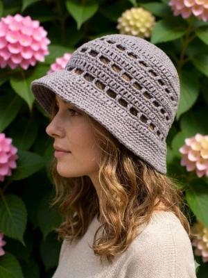 Grå virkad bucket hat - Snygg grå bucket hat i virkad stil med bred brätte och luftiga hålmönster. Perfekt accessoar för en avslappnad look och passar till många outfits. Hatten är tillverkad i mjukt garn och har en modern, trendig form.