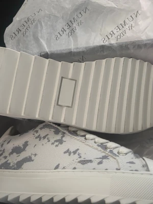 Vita sneakers från Numeris med mönster - Snygg vita Numeris. Köpte fel storlek och vill gärna bli av med den. Skicka bud kan tänka mig sänka vid snabb affär/ storlek 43 helt nya 
