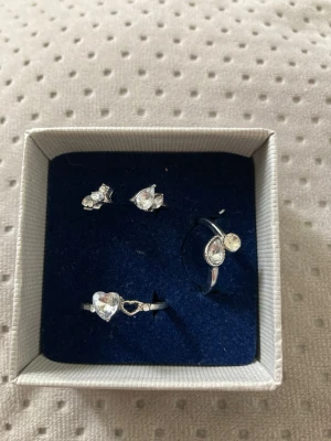 Smyckesset med olikaformade stenar - Säljer ett smyckesset med 3 ringar i silverfärg. Alla smycken har klara, olikformade stenar som ger en glittrig och elegant look. Perfekt för dig som gillar stilrena accessoarer med lite extra bling.