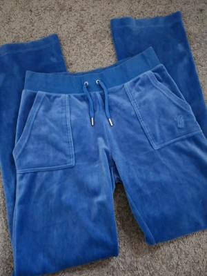 juicy couture byxor - Säljer ett par fina juicy couture byxor i färgen blå. Båda metal sakerna är kvar inga defekter på dom.