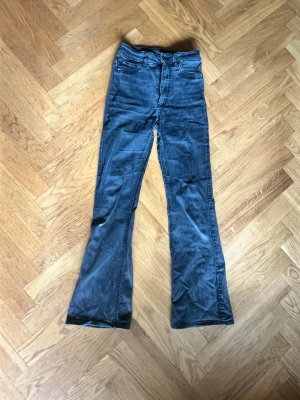 Blå bootcut jeans från Cubus - Säljer ett par blå bootcut jeans från Cubus med hög midja och klassiska fem fickor. Jeansen har dragkedja och knapp framtill samt utsvängda ben. Perfekta för dig som gillar en retroinspirerad look.