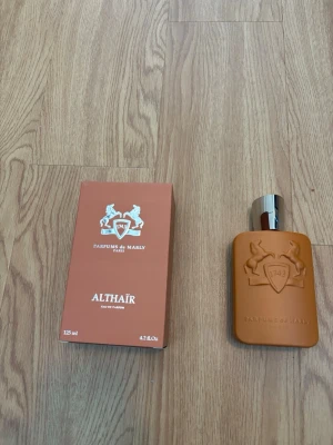 Parfums de Marly Althaïr EdP 125ml - Exklusiv parfym från Parfums de Marly, modellen Althaïr. Flaskan är i matt brun färg med silverfärgad kork och har ett elegant reliefmönster med logotyp och hästar. Förpackningen matchar flaskans färg och har tydlig branding. Volym: 125 ml.