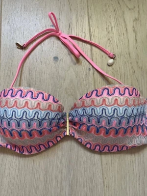 Färgglad bikiniöverdel Missoni - Säljer en snygg bikiniöverdel med Missoni mönster i rosa, blått, beige och vitt. Bikinin har guldfärgad detalj framtill. Perfekt för strandhäng och sommarens alla bad. Storlek S, kupa B-C