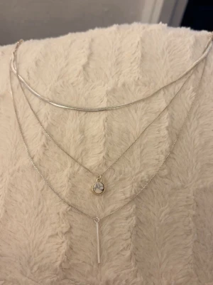 Silver halsband - Ett silvrigt halsband med tre olika band i ett 