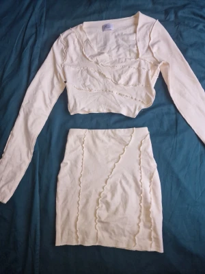 Ljusgult tvådelat set från Oh Polly  - Sommrigt tvådelat set med långärmad crop top och matchande kjol. Setet har dekorativa vågiga sömmar och är väldigt fint till sommaren. Oh Polly är oftast något små i storleken så passar även XS. Finns en liten kaffefläck på kjolen (se sista bilden). Därav säljes det billigt 💛