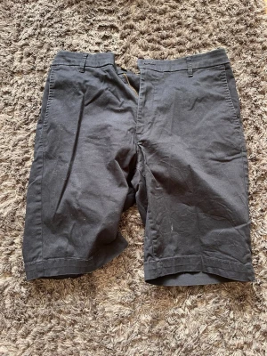 Mörkblåa shorts i bomull - Klassiska mörkblåa shorts i bomull med normal passform. De har bälteshällor i midjan och enkel design utan synliga detaljer. Perfekta för varma dagar och enkla att matcha med olika stilar.