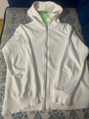 Vit hoodie med dragkedja - En stilren vit hoodie med dragkedja framtill och huva. Tillverkad i mjukt bomullstyg med ribbade muddar vid ärmslut och nederkant. Perfekt för en avslappnad och enkel look. Passar till det mesta och är superbekväm. Den är köpt från 157.