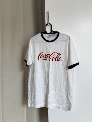 Vit Coca-Cola t-shirt från Zara - Vit t-shirt från Zara med Coca-Cola-tryck i rött. Storlek M.