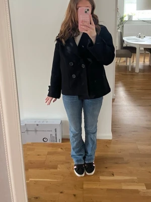 Blå bootcut jeans från Gina Tricot - Säljer ett par klassiska blå bootcut jeans från Gina Tricot. Jeansen har snygga bakfickor med lock och silverknappar samt en skön passform. Perfekta till vardags och lätta att matcha med olika stilar. Materialet är mjukt denim med lite stretch. Sitter jättebra i rumpan.