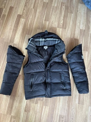 Burberry väst + armar  - Säljer min fina burberry jacka som man även kan göra till väst vilket är perfekt till sommaren som snart kommer. Den är väldigt skön och fin. Skicket är som helt nytt! Inga skador eller effekter skicket är som helt nytt. Jag kan släppa den för billigare om man ej vill ha med armarna 