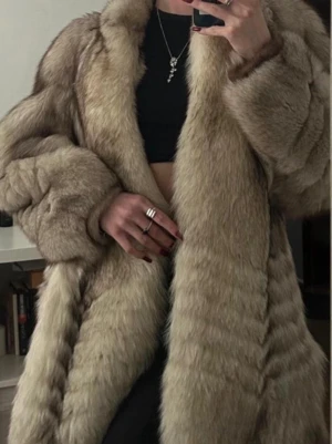 Beige vintage blåräv pälsjacka - Säljer en fluffig och oversized blåräv beige pälsjacka i klassisk modell. Jackan har bred krage, långa ärmar och stängs framtill. Pälsen har naturliga skiftningar i beige och ljusbrunt som ger en lyxig känsla. Perfekt för dig som vill sticka ut i vinter.