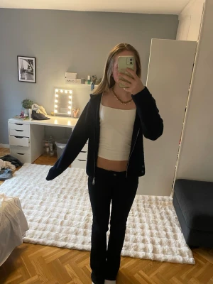 Mörkblå zip hoodie med huva - Säljer en mörkblå hoodie med dragkedja och huva. Hoodien har en enkel och clean design utan tryck eller logga. Passar perfekt till ett avslappnat streetwear-look och är gjord i mjukt material. Långa ärmar.