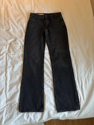 Svarta Zara jeans - Säljer ett par svarta jeans från Weekday med rak passform och klassisk femficksdesign. Jeansen har hög midja och är tillverkade i ett kraftigt denimtyg. Perfekta för dig som gillar en stilren och tidlös look.