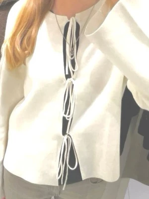 Vit stickad tröja med knytning - Trendig vit stickad tröja från Gina Tricot med unik knytning framtill. Tröjan har långa ärmar, ribbad halsringning och en rak passform. Perfekt för dig som gillar en stilren men ändå cool look. Andvänd en gång, inga tecken på slitage.