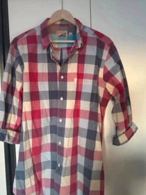 Rutig skjorta i rosa och blått - Säljer en klassisk rutig skjorta med stora rutor i rosa, blått, vitt. Skjortan har långa ärmar, knappar framtill och en bröstficka. Tillverkad i mjuk bomull, perfekt för en avslappnad och trendig stil.