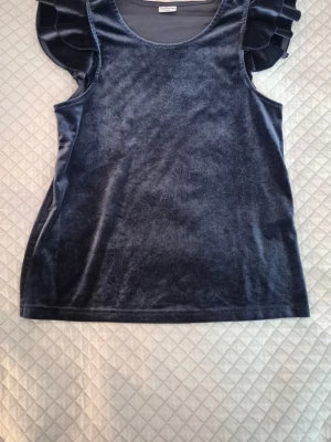 Elegant topp i blå sammet  - Mycket fin festtopp i blå sammet🌟 Volanger vid ärmarna. Passar storlek XS. Inga anmärkningar! Från Jaqueline de Yong. 