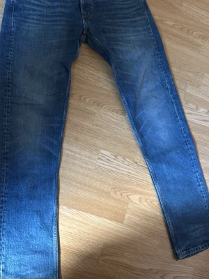 Blå jeans Replay Grover straight fit - Säljer ett par klassiska blå jeans från Replay, modell Grover med straight fit. Jeansen har fem fickor, snygga slitningar och kontrastsömmar. Om du har frågor så är de bara att ställa! 