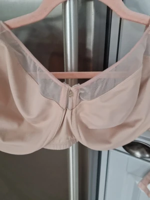 Beige bh från Change  - Stilren beige bh med mjuka kupor och transparent mesh upptill. Bh:n har breda axelband för extra stöd. Använd några gånger bara. I mycket gott skick.