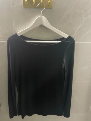 Svart långärmad topp från Intimissimi - En stilren svart långärmad topp från Intimissimi med rund halsringning. Tillverkad i mjukt och stretchigt material som sitter skönt mot kroppen. 