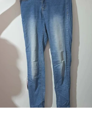 Blå slim fit jeans från Pro Moda - Snygga blå slim fit jeans från Pro Moda med ljusa slitningar på framsidan. Klassisk femficksmodell med kontrastsömmar och normal midja. Perfekta till en avslappnad streetstyle-look.