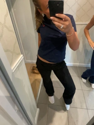 Mörkblå t-shirt från Polo Ralph Lauren - Snygg mörkblå t-shirt från Polo Ralph Lauren med klassisk passform och diskret logga på bröstet. Tillverkad i mjuk bomull som känns skön mot huden. Perfekt till jeans eller shorts för en clean och enkel look.