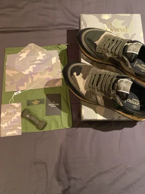 Valentino rockrunner - Säljer dessa riktigt snygga valentino rockrunners i storlek 43. Det är endast använda ett par fåtal gånger som syns på bild 2 på undersidan av skon. Vid köp får man med allt som visas i bild 1. Dvs låda, tackkort, dustbag, tags och ett par extra snören. Tveka inte på att skriva vid några som helst funderingar