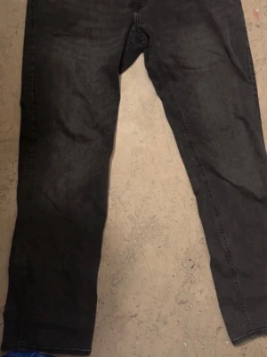 Svarta raka jeans - Säljer ett par svarta jeans med rak passform och klassisk femficksdesign. Jeansen har diskreta sömmar och är tillverkade i ett mjukt denimtyg som ger en avslappnad look. Perfekta till sneakers eller boots.