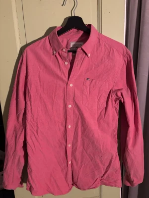 Lexington skjorta - Säljer en klassisk rosa skjorta från lexington med button-down krage och bröstficka med liten logga. Skjortan har långa ärmar, vita knappar och är gjord i mjuk bomull. Perfekt för dig som gillar stilrena plagg med en färgklick.