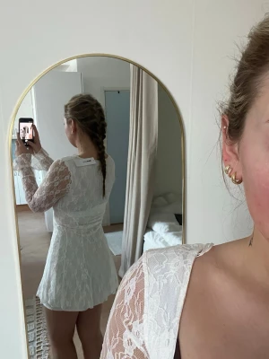 Superfin spetsklänning från Gina Tricot – perfekt till studenten! ✨ - Säljer denna otroligt fina vita spetsklänning. Den har fina detaljer med knytning framtill, fyrkantig urringning och klockade ärmar som ger en jättefin siluett!  Klänningen är helt ny och endast provad 